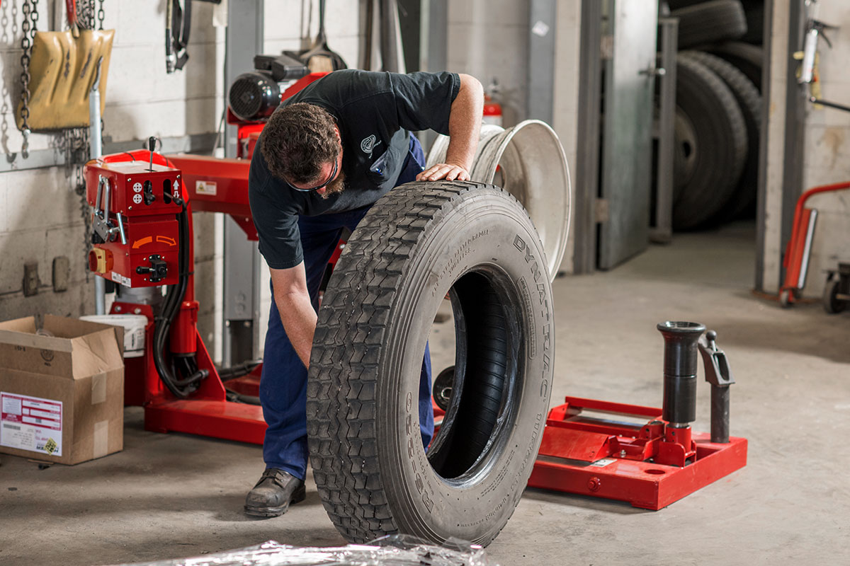 tech applying lube to heavy duty tire