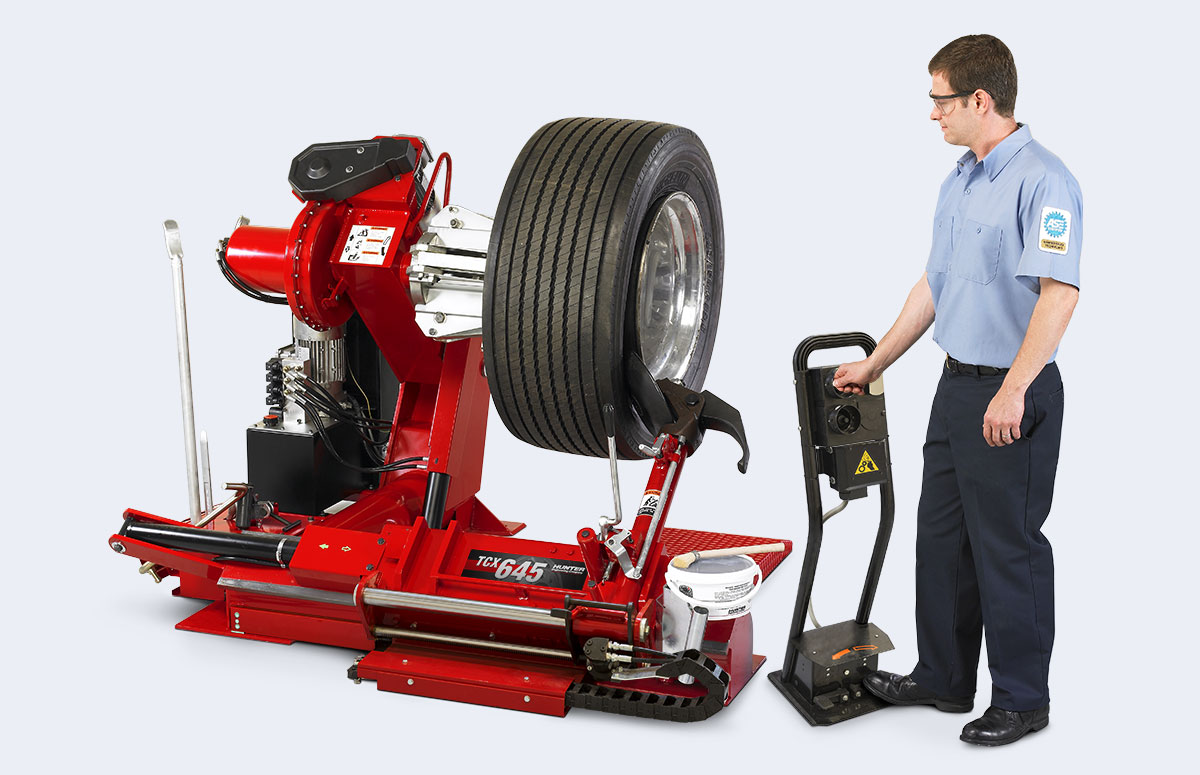 operator using pedestal control unit on hunter tcx645HD tire machine